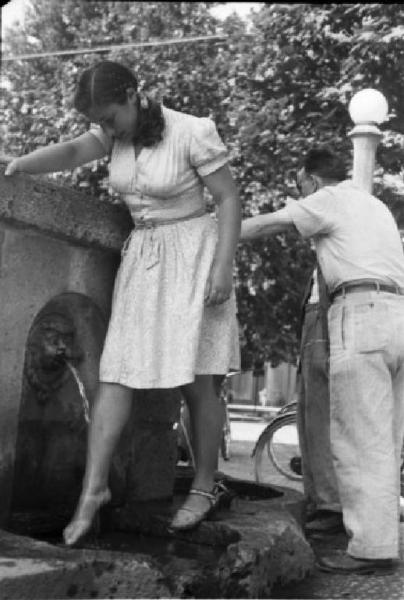 Figura 4: Una ragazza si rinfresca bagnandosi le gambe alla "Fontana dell'acqua marcia" (Lombardia Beni Culturali, autore Federico Patellani, 1946)